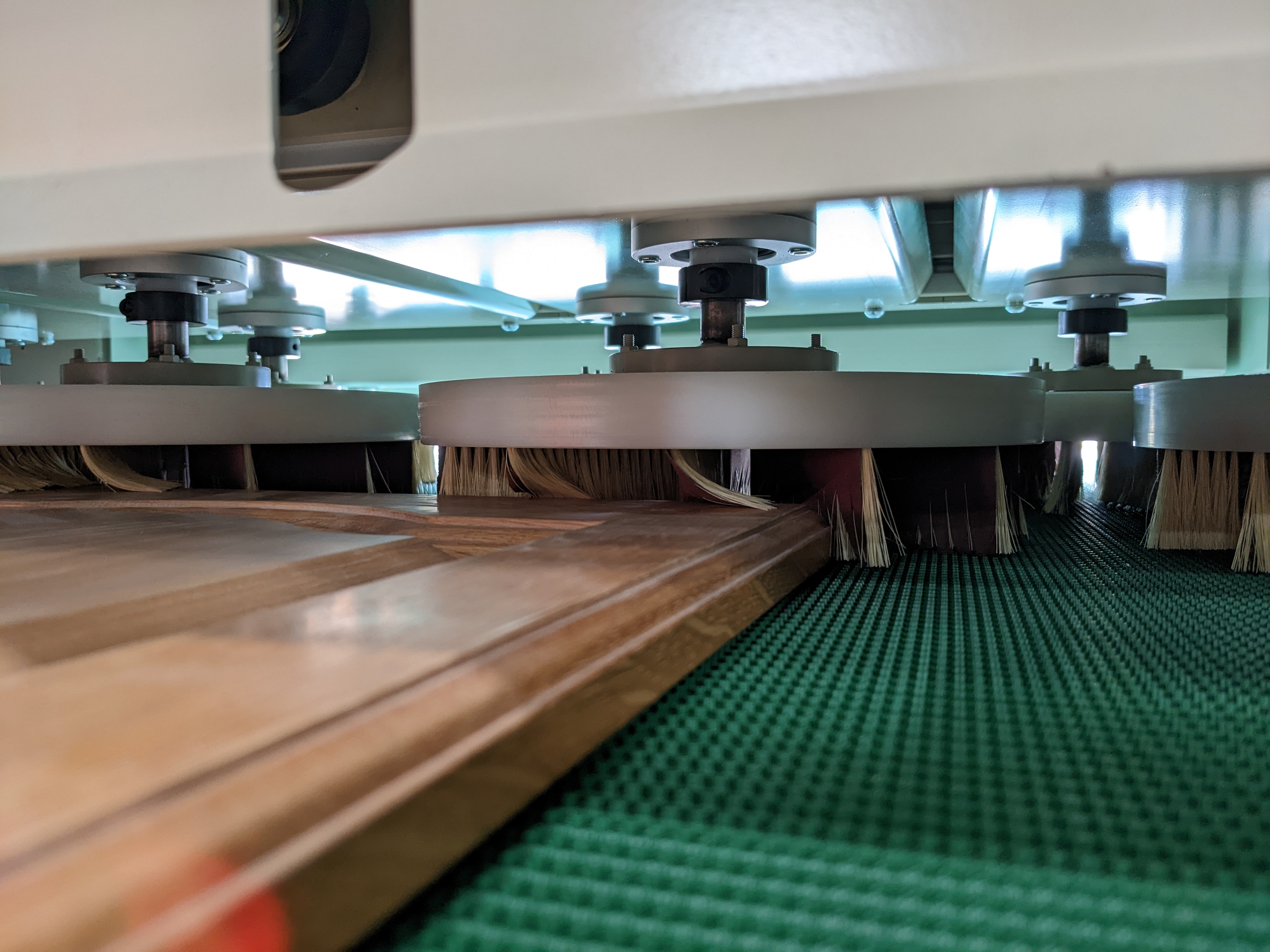 Photo of the sanding head of the Gibbs Cup Brush sanding machine